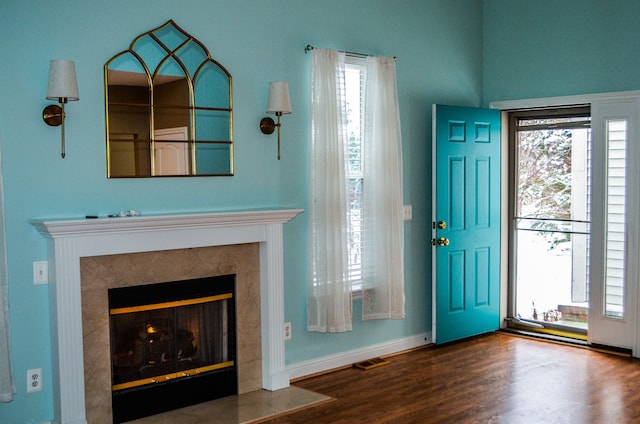 entrance foyer with a high end fireplace and hardwood / wood-style floors