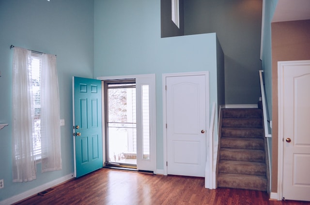 foyer with dark hardwood / wood-style flooring and a high ceiling