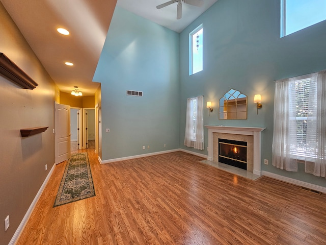 unfurnished living room with visible vents, baseboards, wood finished floors, and a fireplace