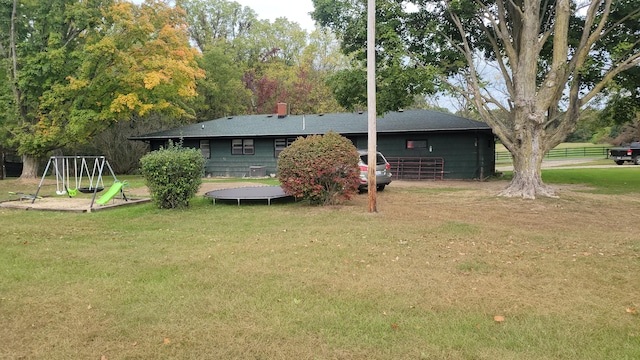 view of yard with a trampoline and a playground