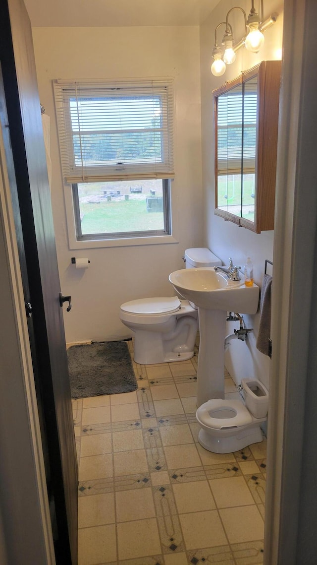 bathroom with a notable chandelier, tile patterned floors, and toilet