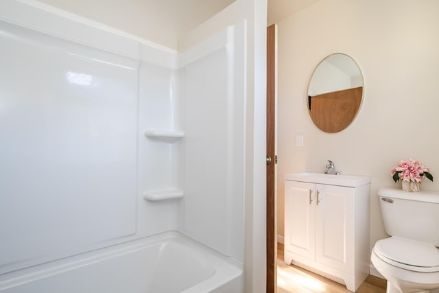 full bathroom featuring vanity, hardwood / wood-style flooring,  shower combination, and toilet