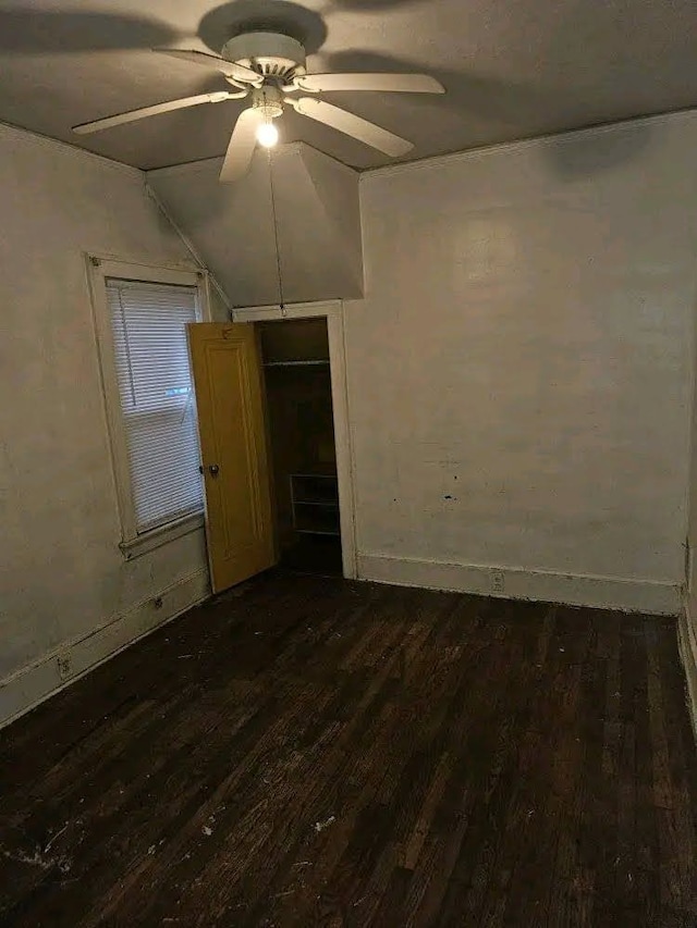 empty room with vaulted ceiling, dark wood-type flooring, and ceiling fan