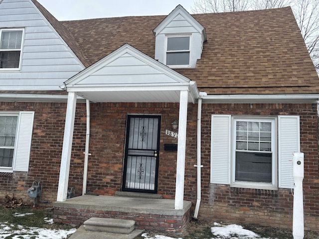 snow covered property entrance with covered porch