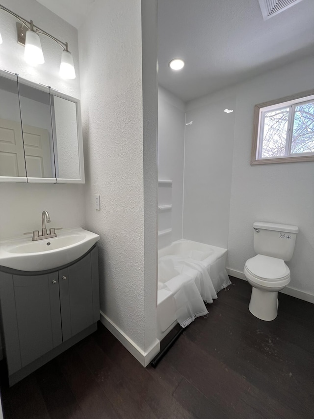 full bathroom featuring wood-type flooring, bathtub / shower combination, vanity, and toilet