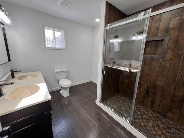 bathroom featuring hardwood / wood-style flooring, vanity, toilet, and an enclosed shower