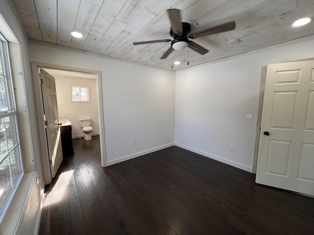 unfurnished bedroom with ceiling fan, dark wood-type flooring, ensuite bathroom, and wood ceiling