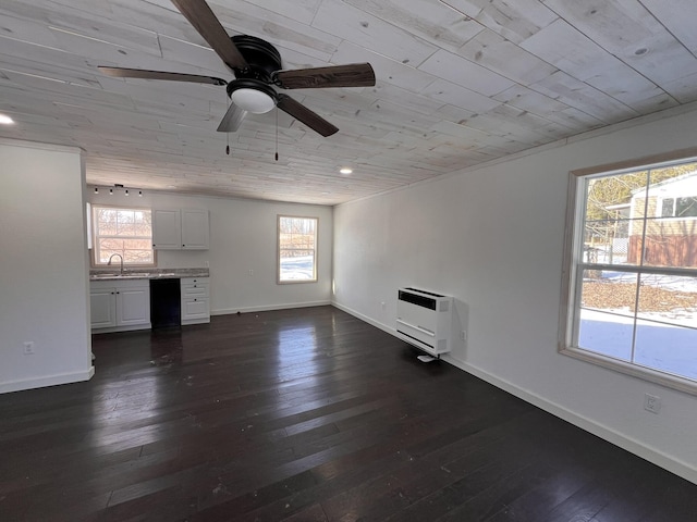 unfurnished living room featuring heating unit, sink, wooden ceiling, and dark hardwood / wood-style floors