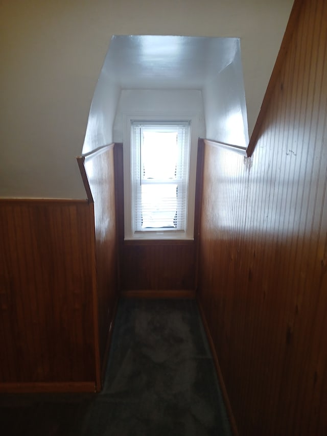 bonus room featuring wood walls