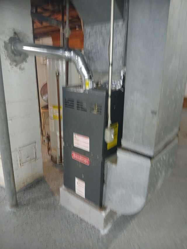 utility room featuring water heater and heating unit