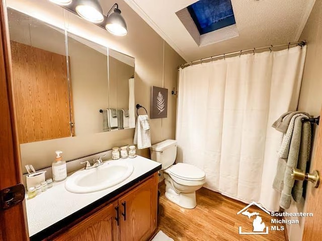 bathroom with hardwood / wood-style flooring, vanity, ornamental molding, toilet, and a textured ceiling