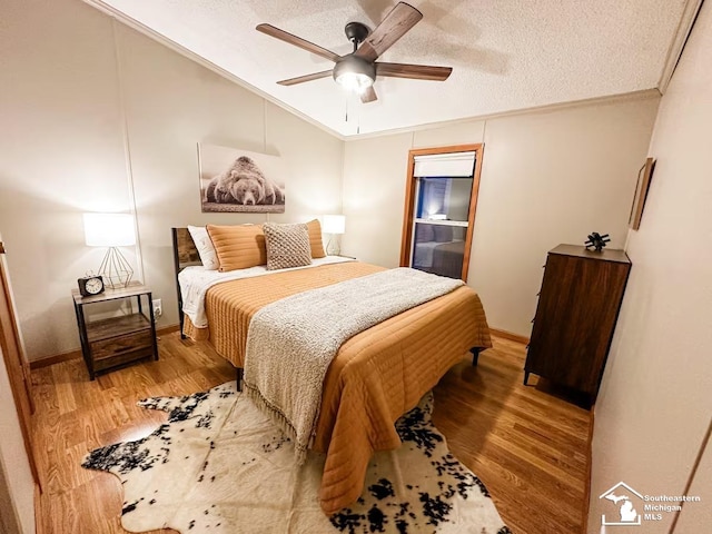 bedroom with crown molding, hardwood / wood-style flooring, a textured ceiling, and ceiling fan