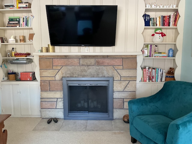 living room featuring built in shelves and a fireplace