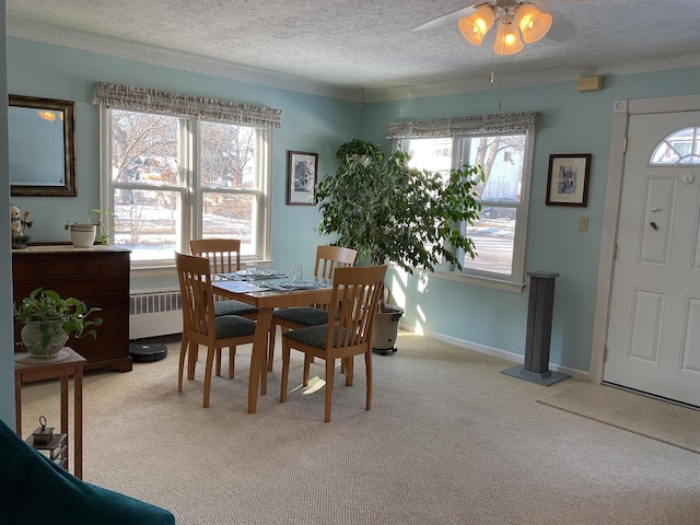 carpeted dining area featuring radiator and a textured ceiling