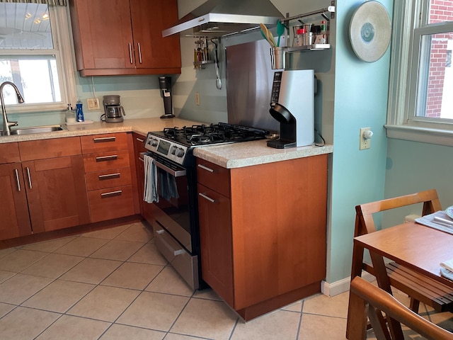 kitchen featuring extractor fan, stainless steel range with gas cooktop, sink, and light tile patterned floors