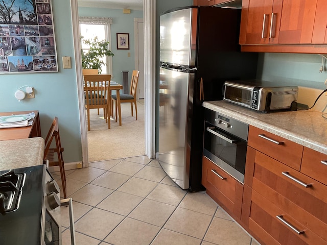 kitchen featuring light colored carpet and stainless steel appliances