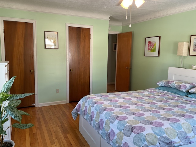 bedroom with ornamental molding, light hardwood / wood-style floors, and a textured ceiling