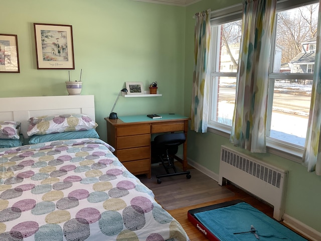 bedroom featuring hardwood / wood-style flooring and radiator