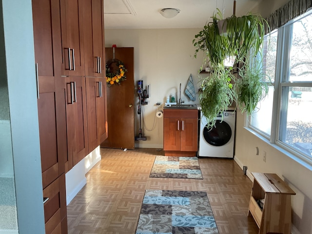 washroom with washer / clothes dryer, plenty of natural light, and light parquet flooring