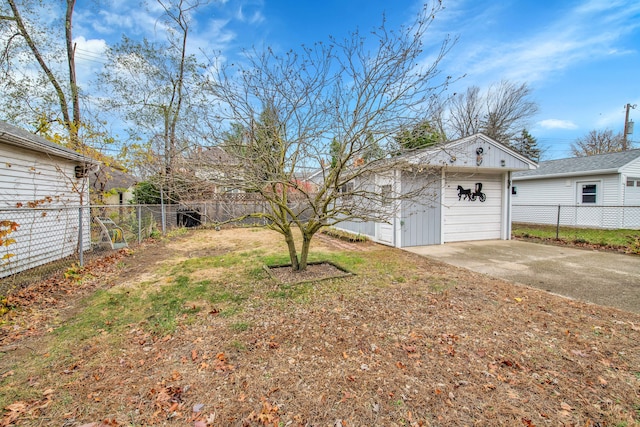 view of yard with a garage and an outbuilding