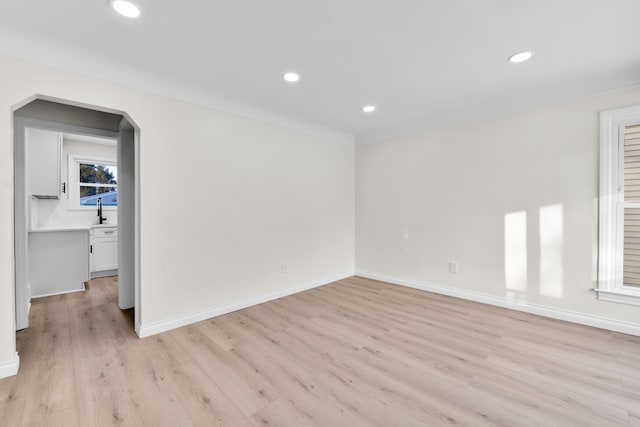 spare room with sink and light hardwood / wood-style floors