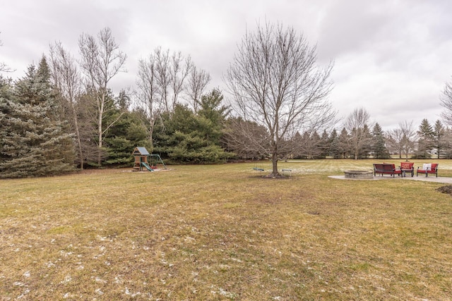 view of yard featuring a playground and a fire pit