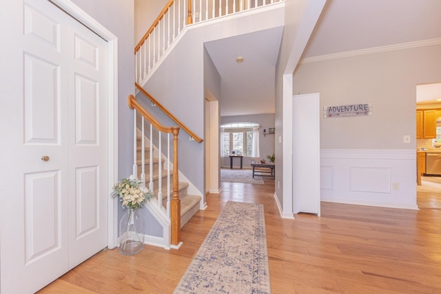 entrance foyer featuring crown molding and light hardwood / wood-style floors