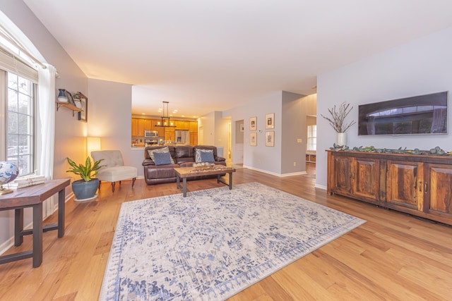 living room featuring a chandelier and light hardwood / wood-style flooring