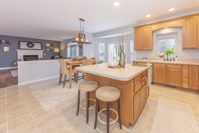 kitchen with sink, decorative light fixtures, light tile patterned flooring, and a kitchen island