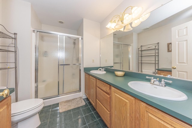 bathroom featuring vanity, toilet, and a shower with shower door