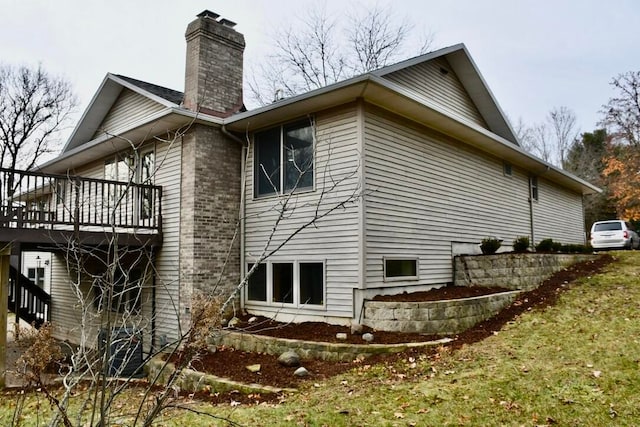 view of property exterior featuring a wooden deck and a yard