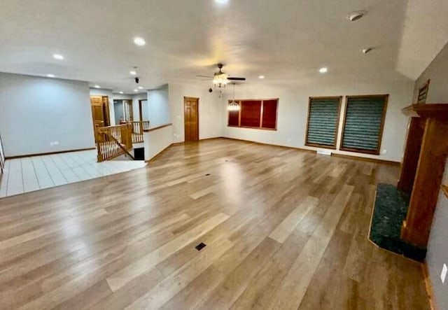 unfurnished living room with hardwood / wood-style flooring and ceiling fan