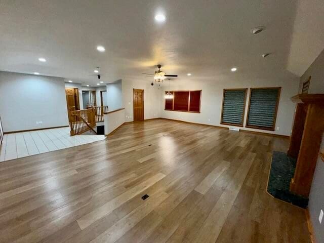 unfurnished living room featuring ceiling fan and hardwood / wood-style floors