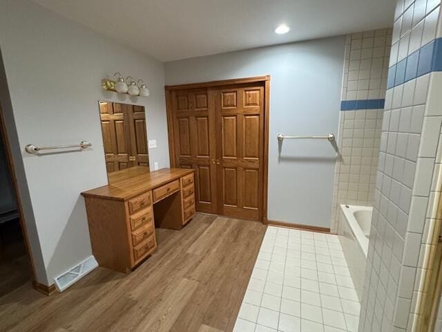 bathroom with wood-type flooring and a bathtub