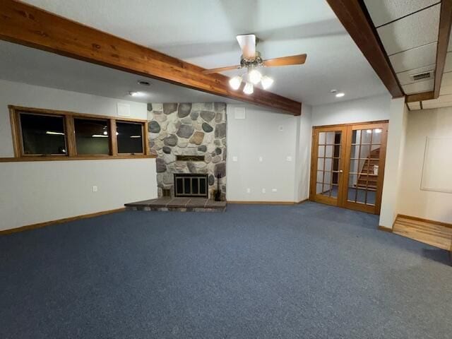 unfurnished living room featuring carpet floors, a fireplace, french doors, and beamed ceiling