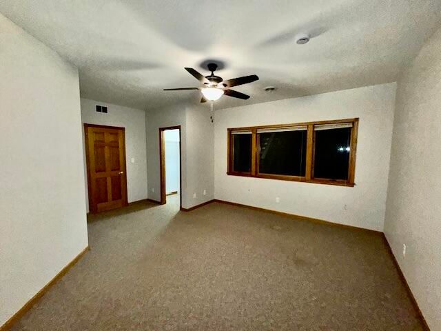 spare room with ceiling fan and carpet floors