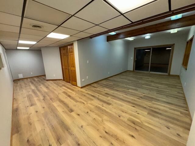 basement featuring light hardwood / wood-style floors and a drop ceiling