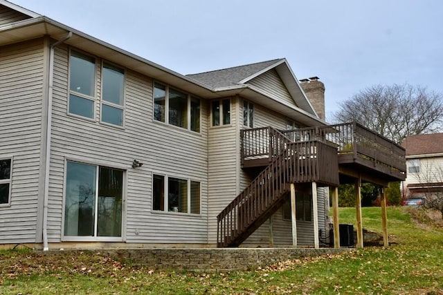 back of property with a wooden deck and a yard