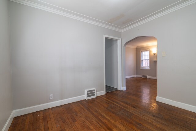 unfurnished room featuring ornamental molding, arched walkways, visible vents, and hardwood / wood-style floors