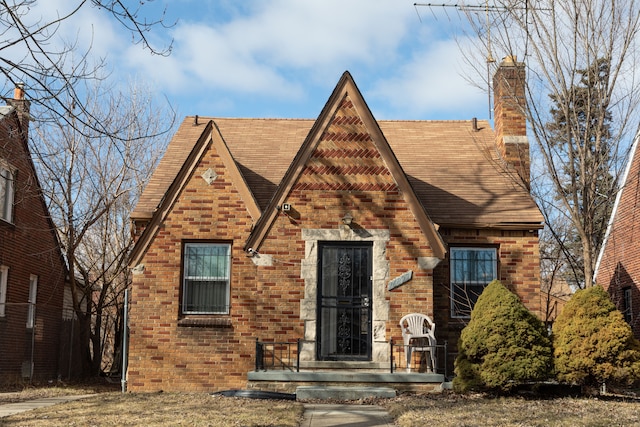 tudor house with brick siding and a chimney