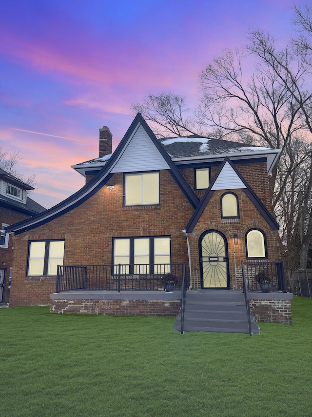 back house at dusk featuring a yard