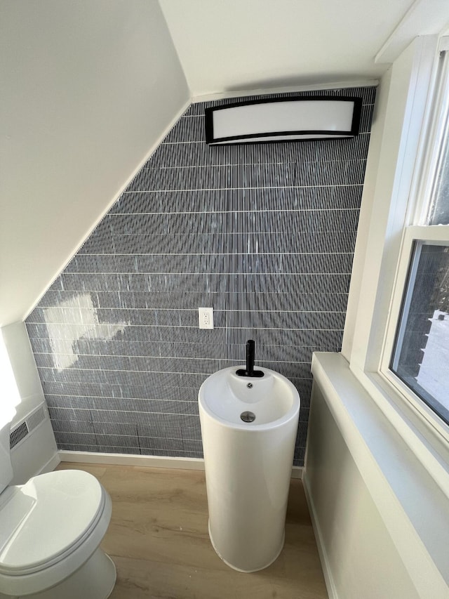 bathroom featuring a bidet, lofted ceiling, toilet, and hardwood / wood-style floors