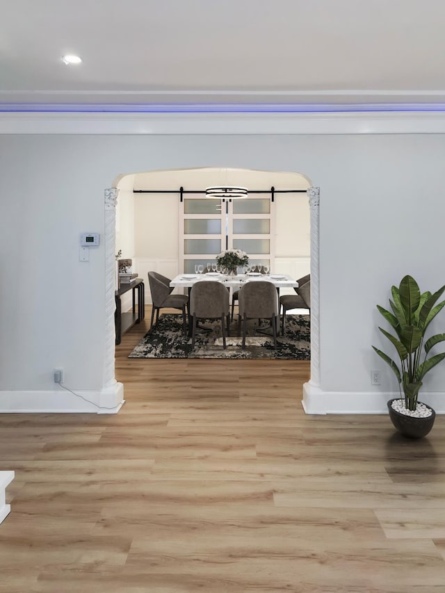 dining room featuring light hardwood / wood-style floors and a barn door