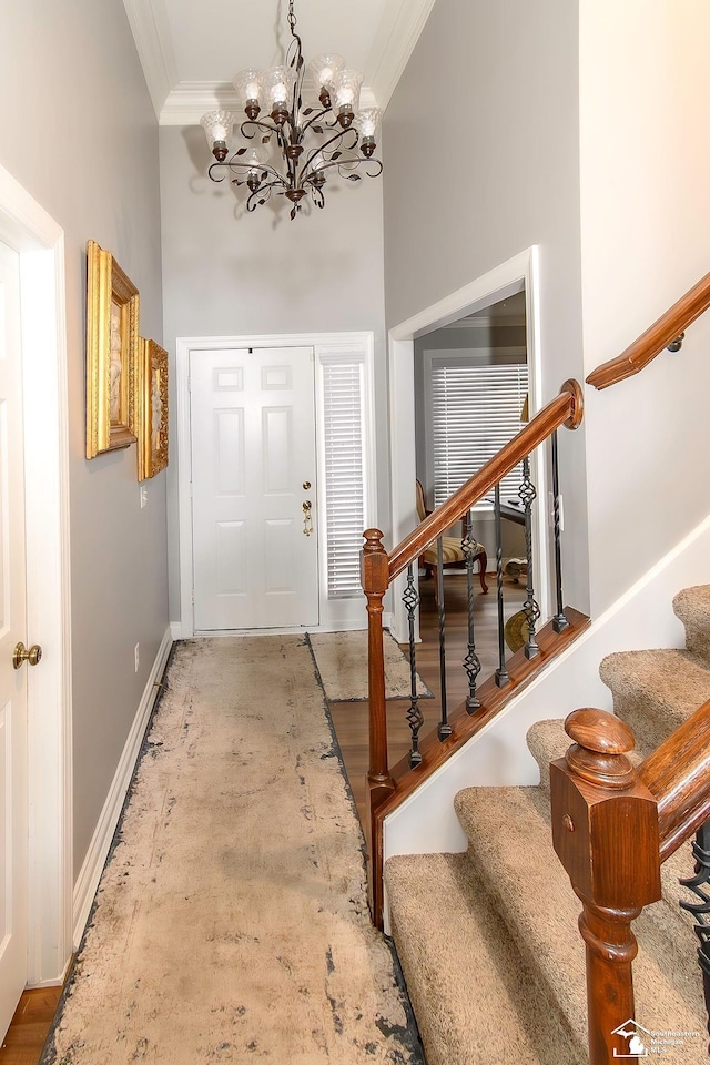 entryway featuring a high ceiling, crown molding, and a chandelier