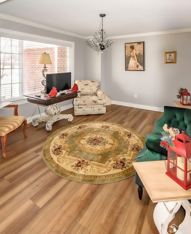 sitting room with crown molding, hardwood / wood-style floors, and a chandelier