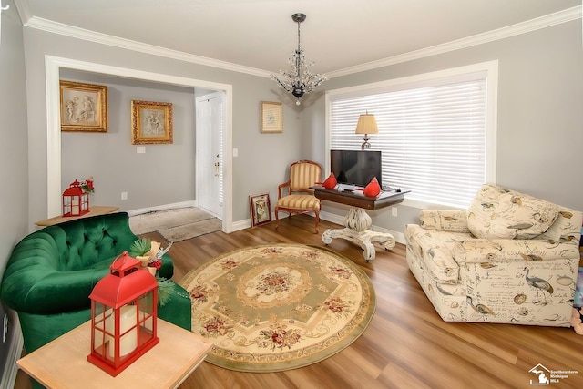 living area featuring hardwood / wood-style flooring, ornamental molding, and a notable chandelier