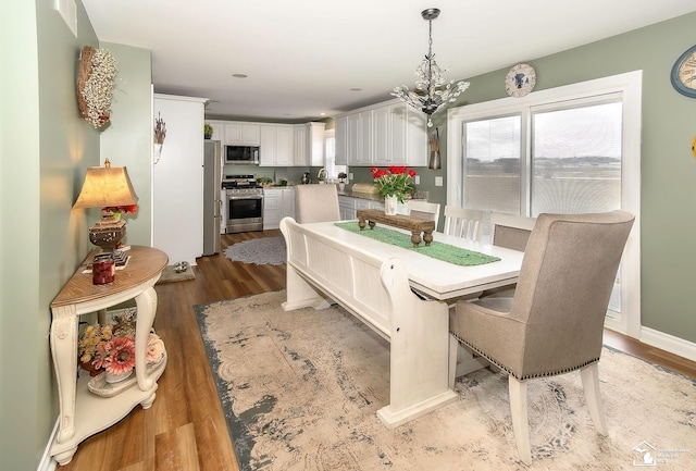 dining area featuring an inviting chandelier, light hardwood / wood-style floors, and a wealth of natural light