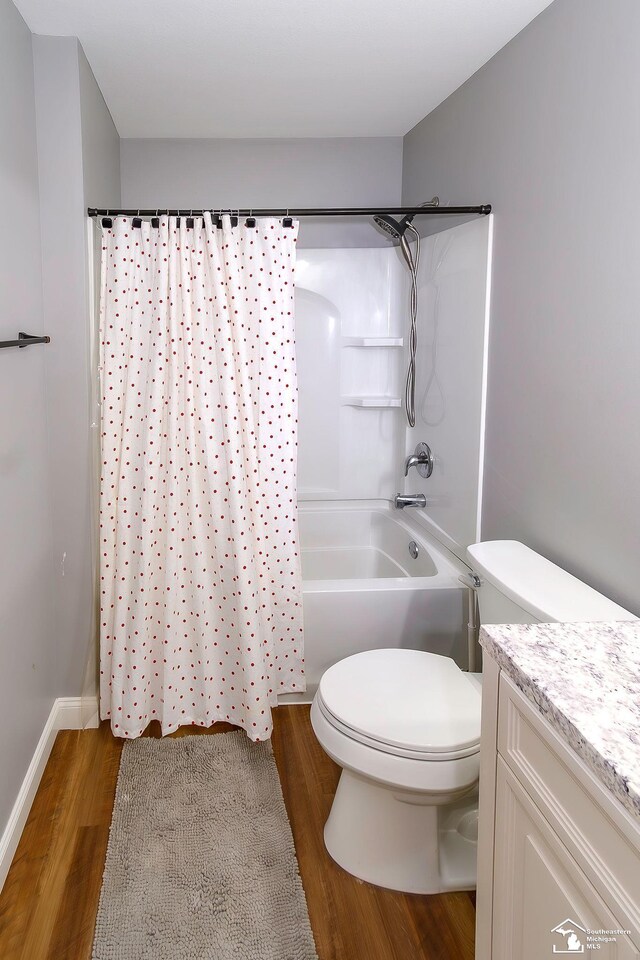 full bathroom with hardwood / wood-style flooring, vanity, shower / washtub combination, and toilet