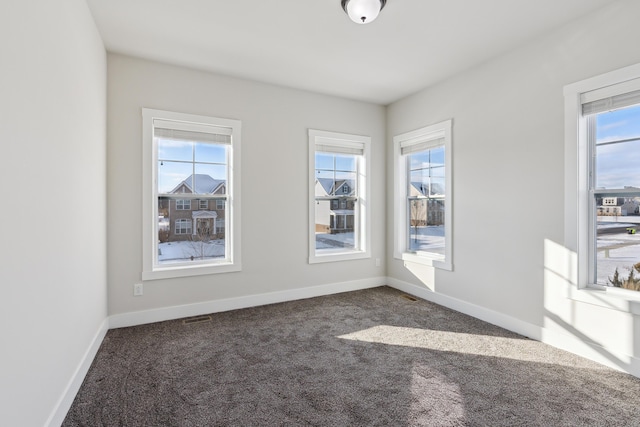 spare room with dark carpet