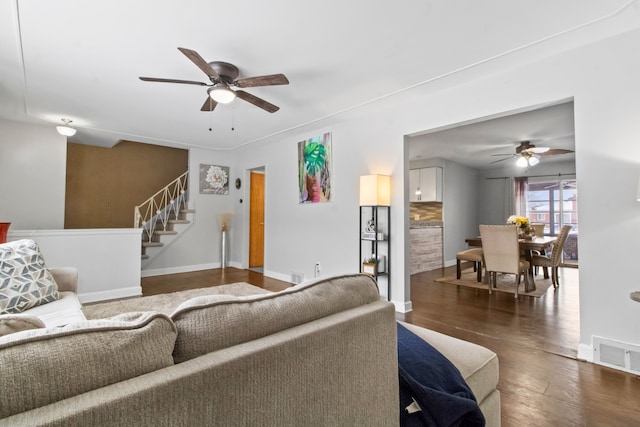 living room with dark hardwood / wood-style flooring and ceiling fan